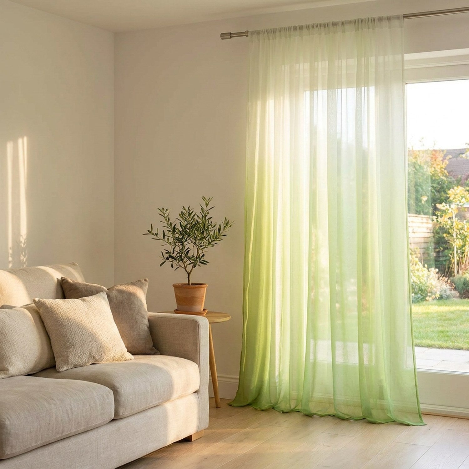 Voilage tulle dégradé vert dans un salon lumineux avec canapé et plante
