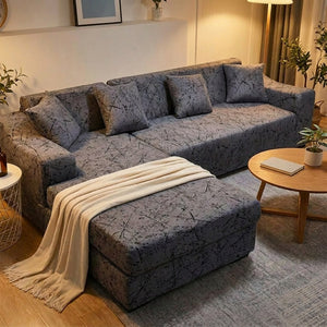 Housse de canapé d'angle grise dans un salon cocooning en soirée avec plaid