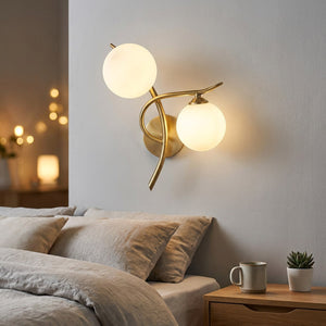 Applique murale dorée au-dessus d'une table de chevet dans une chambre cocooning