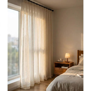 Voilage blanc suspendu dans une chambre lumineuse près du lit