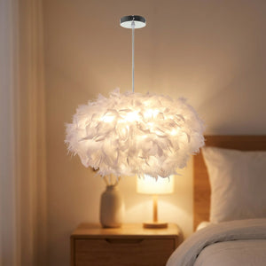 Suspension boule de plumes blanches au dessus d'une table de chevet dans une chambre chaleureuse