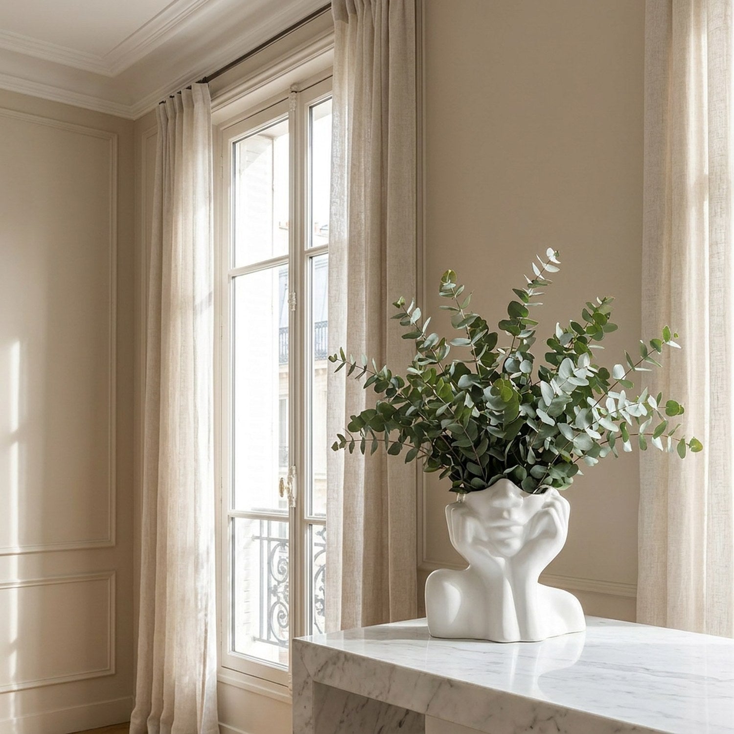 Vase céramique visage avec eucalyptus sur surface marbre lumière naturelle