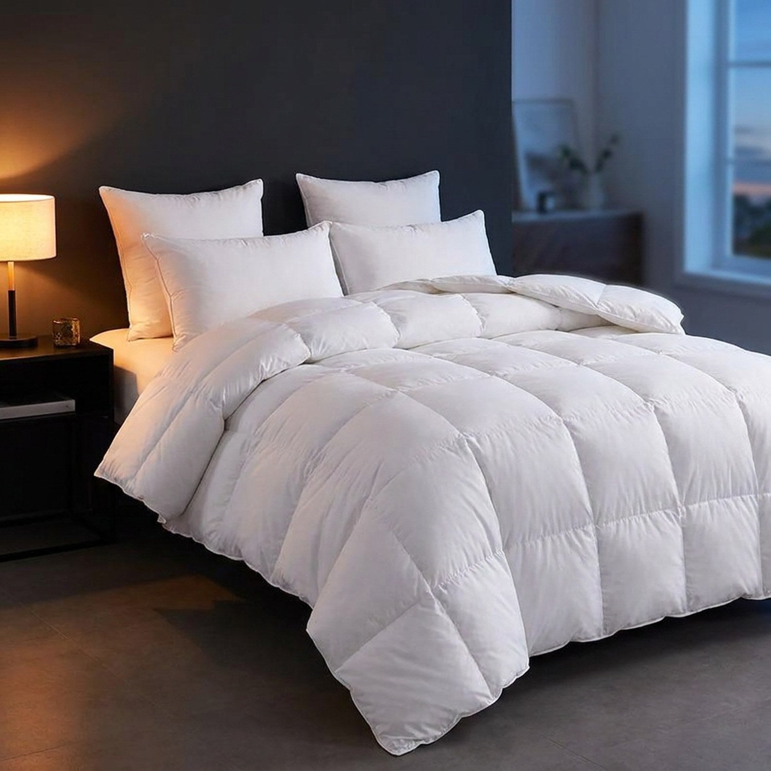 Couette blanche sur un lit dans une chambre moderne avec lampe de chevet allumée