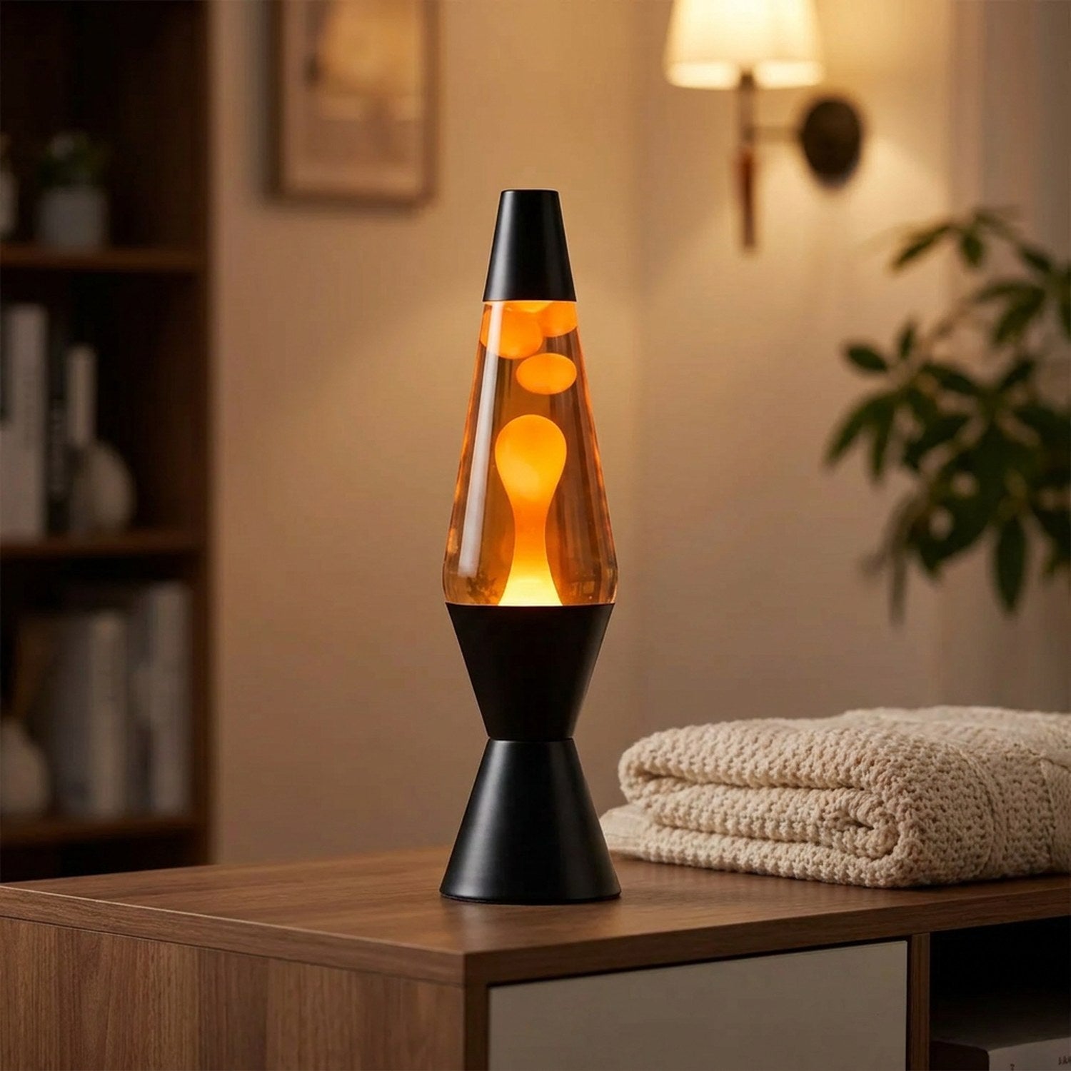 Lampe à lave allumée sur une console dans un salon cosy avec plaid