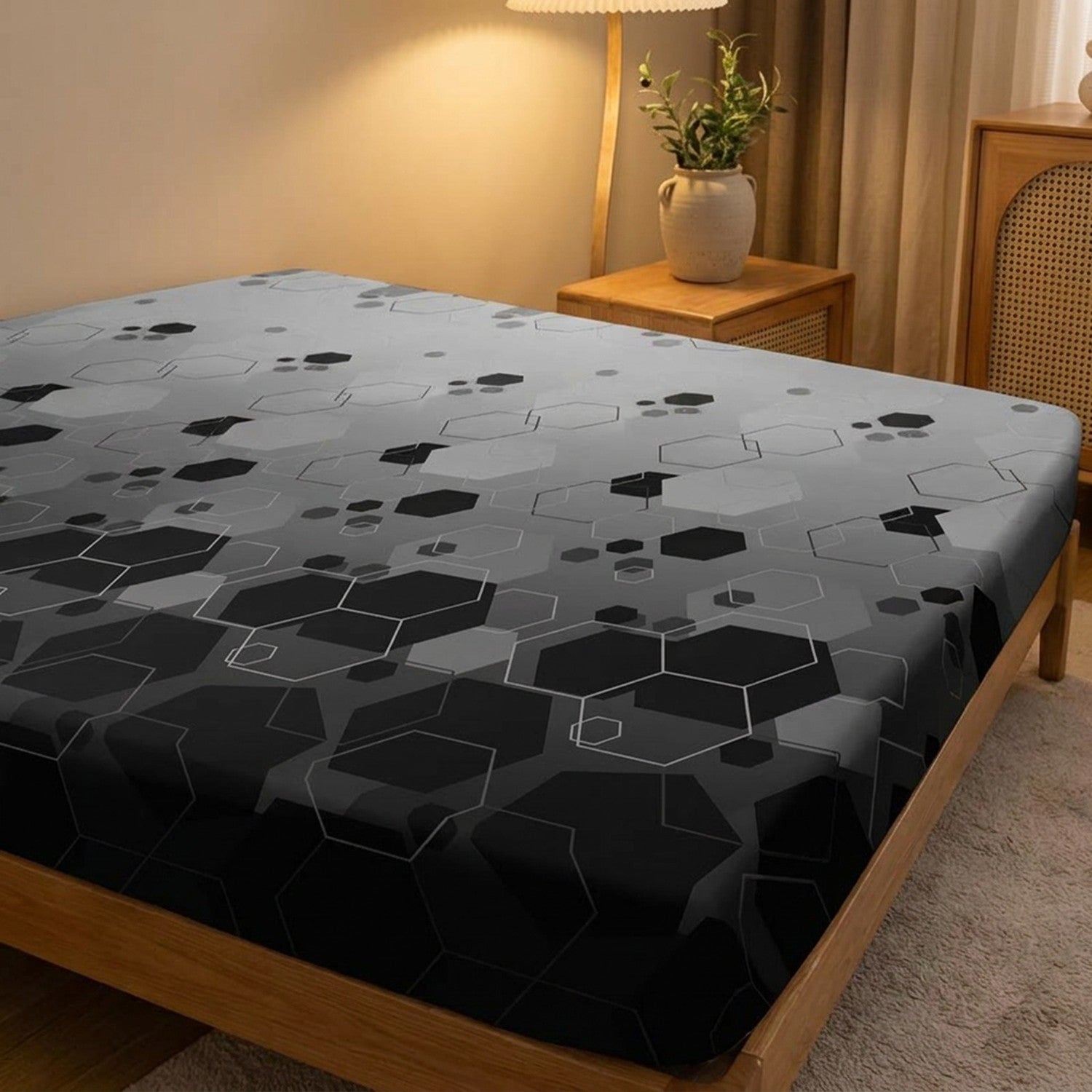 Drap-housse à motif hexagones sur un lit dans une chambre chaleureuse le soir