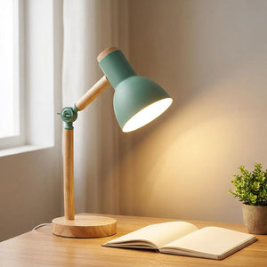 Lampe de bureau verte éclairant un carnet ouvert sur un bureau en bois