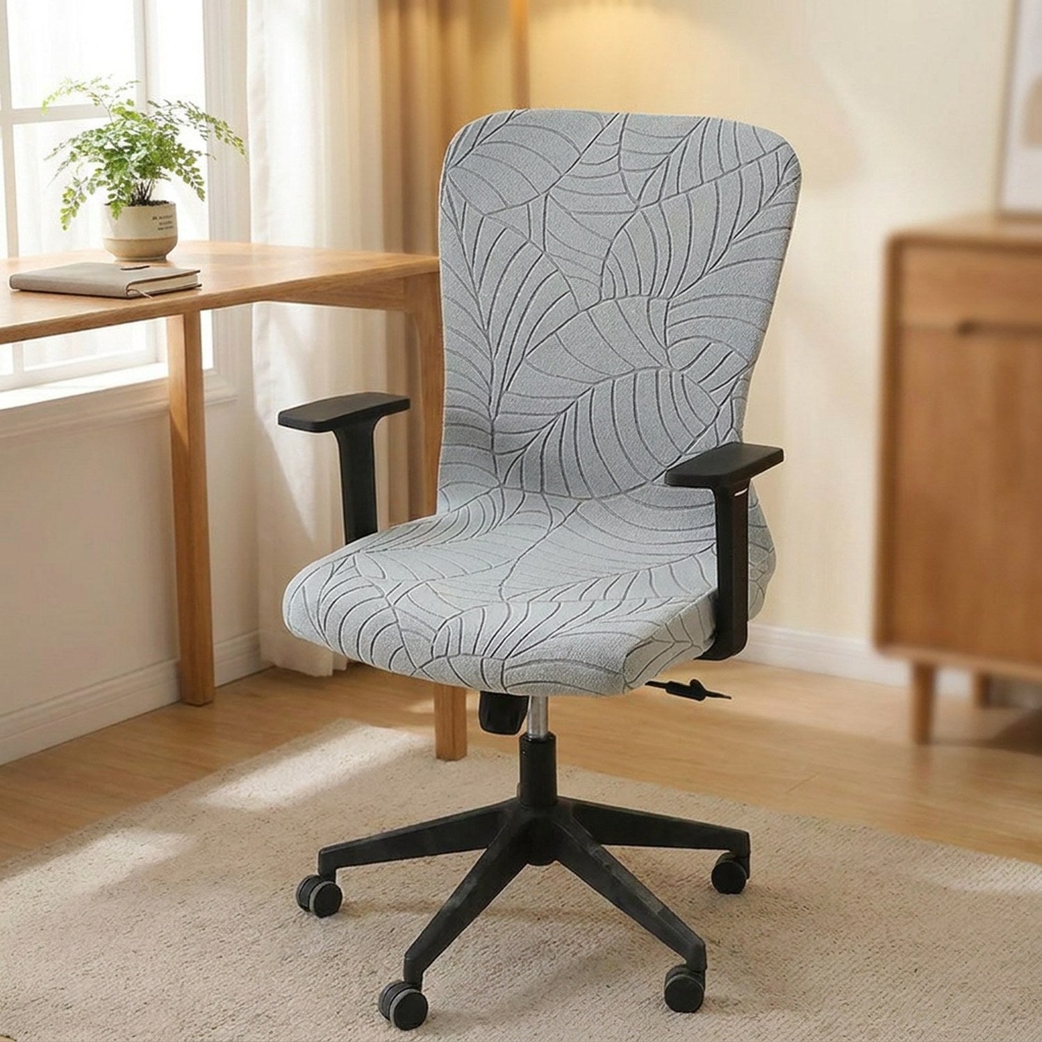 Chaise de bureau avec housse grise dans un coin travail lumineux avec plante et fenetre