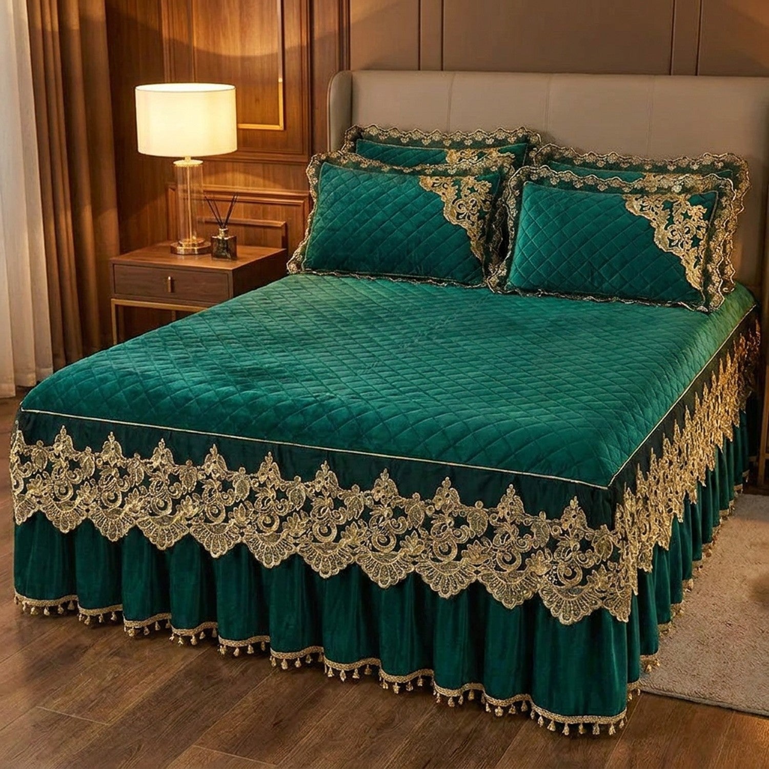 Couvre-lit vert foncé à broderie dorée sur un lit avec table de chevet et lampe chaleureuse