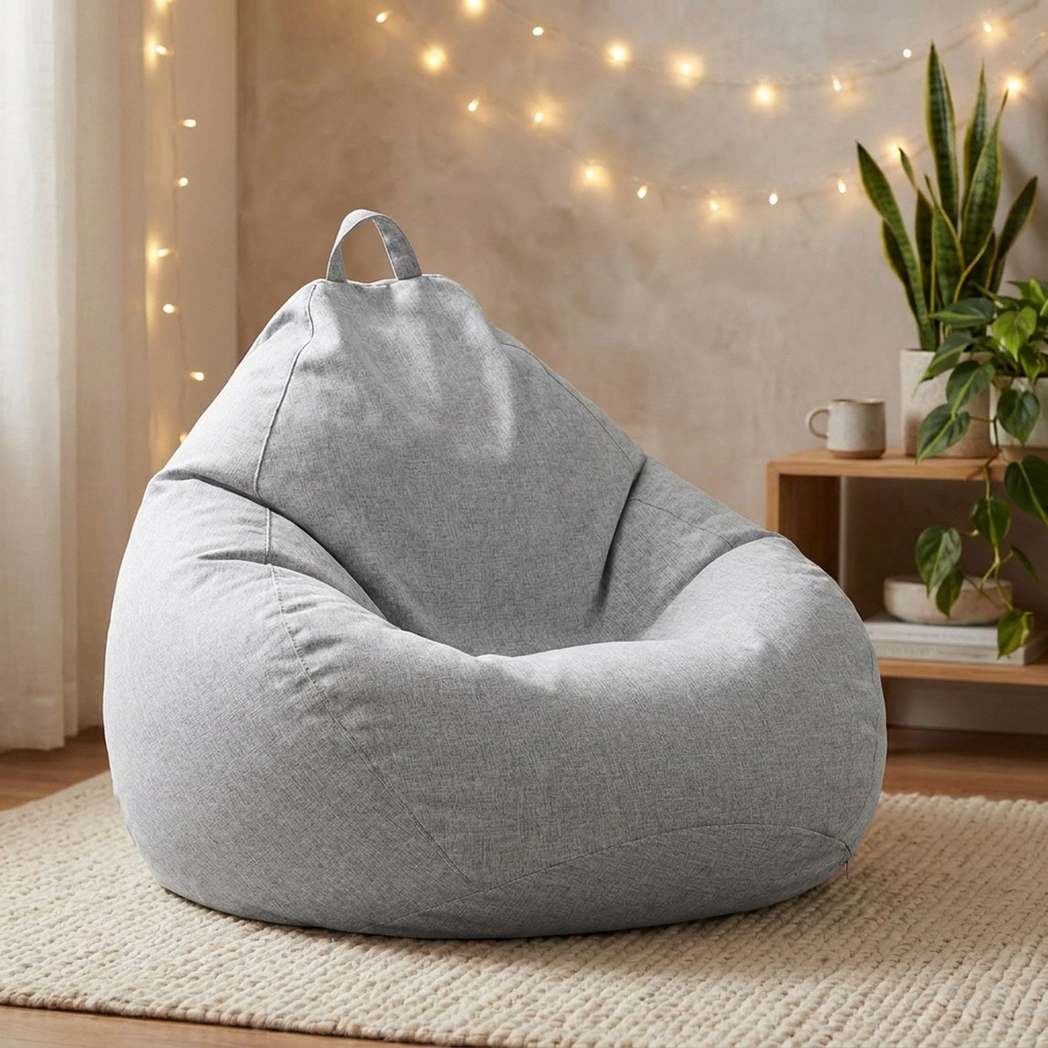Pouf poire gris dans un coin cocooning avec guirlande lumineuse et plantes