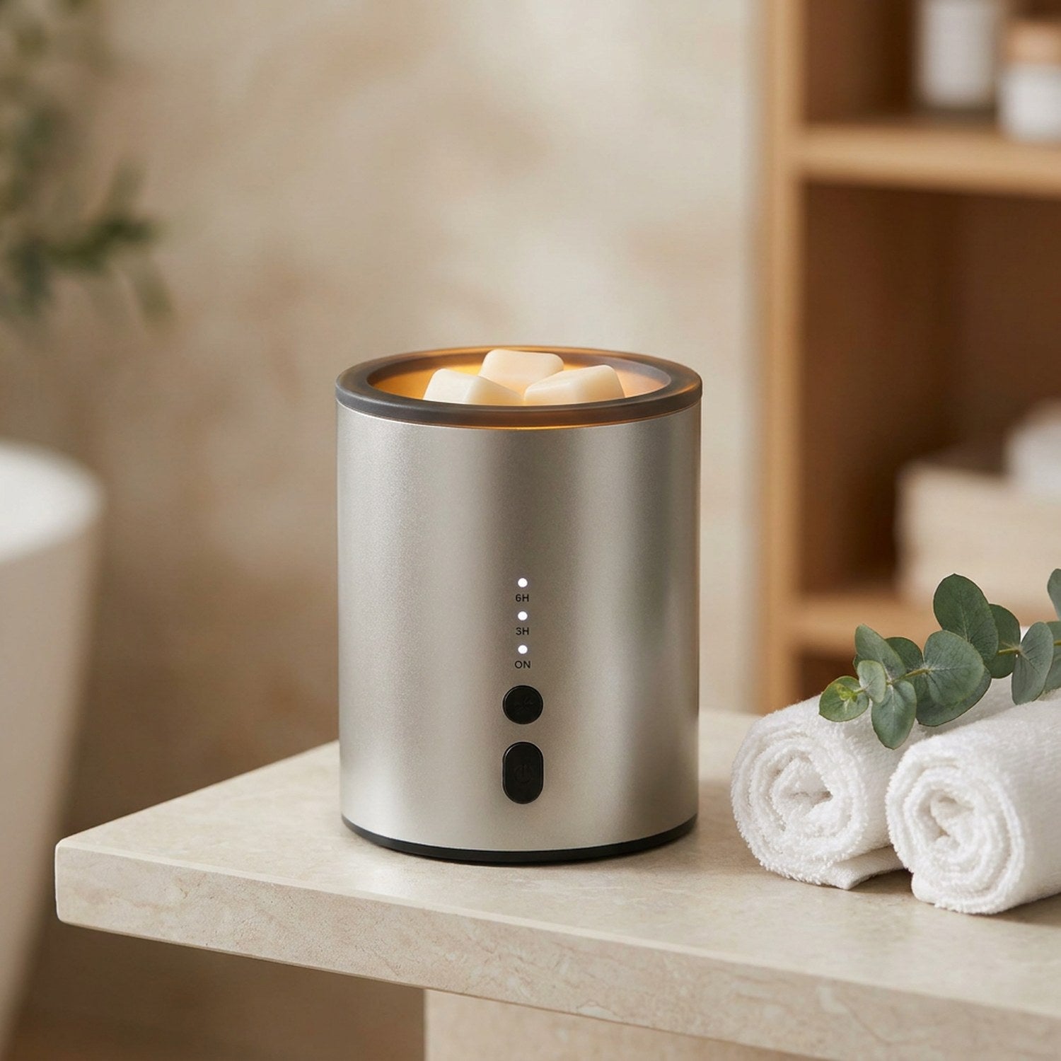 Brûle-parfum électrique argenté sur une étagère de salle de bain avec serviettes et eucalyptus
