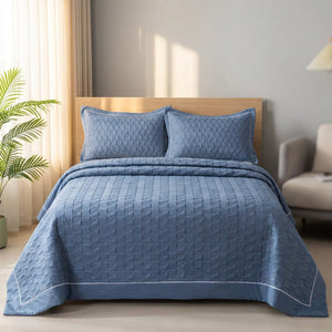 Couvre-lit matelassé bleu dans une chambre scandinave lumineuse avec plante verte
