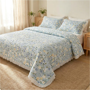 Couvre-lit matelassé fleuri bleu sur un lit près d'une fenêtre lumineuse