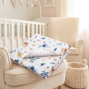 Couverture bébé minky pliée sur un fauteuil de chambre d'enfant