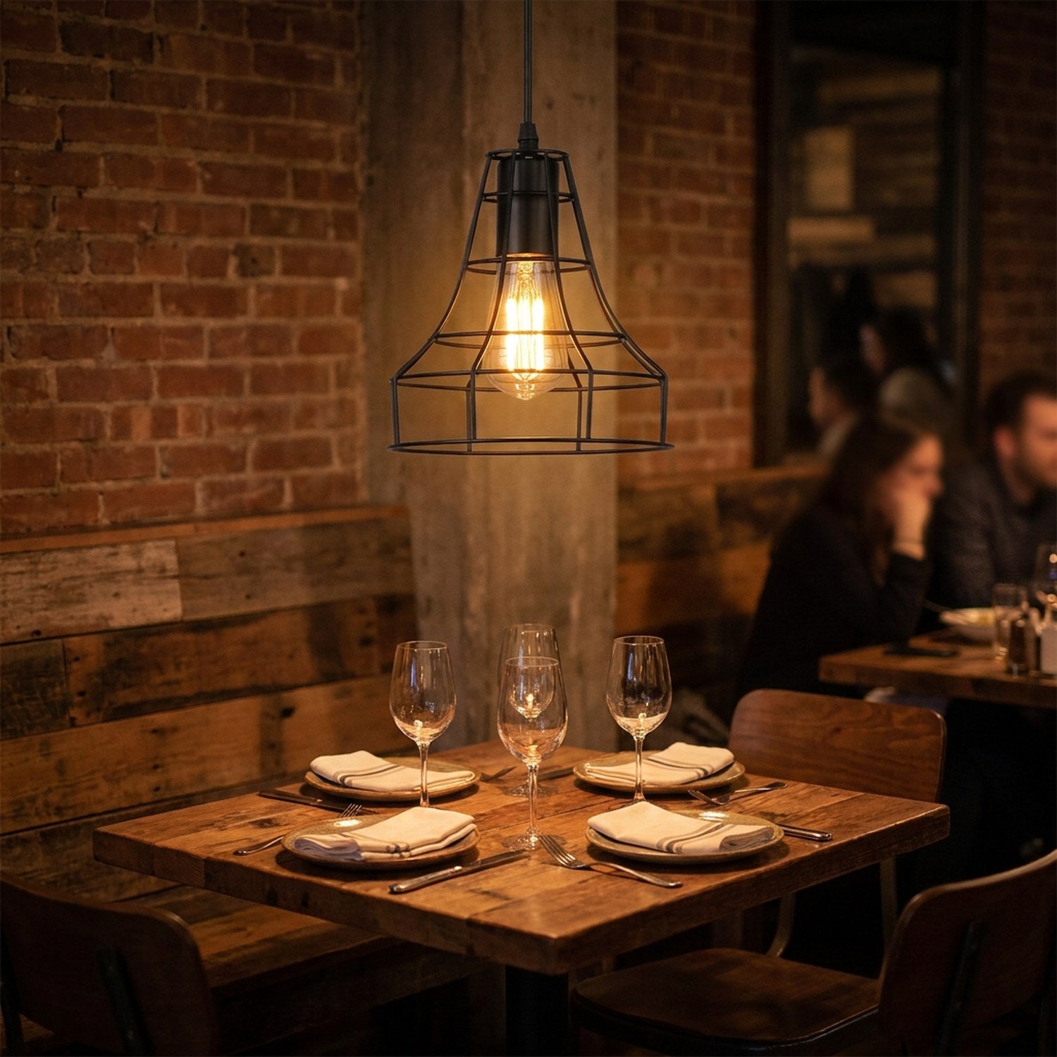 Suspension industrielle cage métal au-dessus d'une table de bistrot dans une ambiance chaleureuse