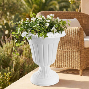 Pot colonne romaine blanc avec lierre retombant sur une terrasse cosy