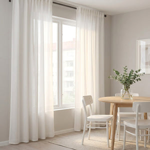 Voilage blanc en tulle transparent habillant une fenêtre dans un coin repas scandinave