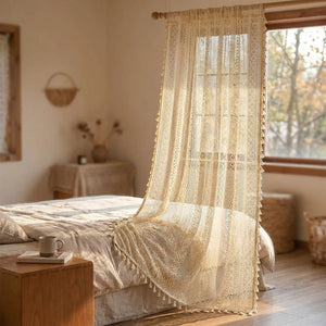 Rideau boho en dentelle au crochet devant une fenêtre de chambre chaleureuse