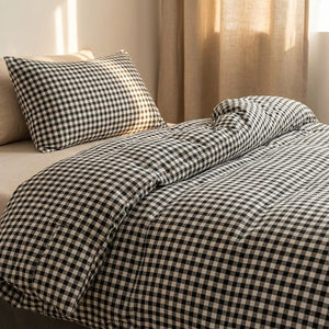 Gros plan sur le tissu à carreaux vichy noirs de la housse de couette et son oreiller