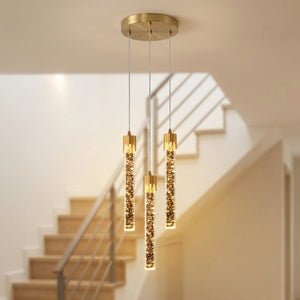 Lustre en cristal doré à trois barreaux allumé dans un escalier moderne