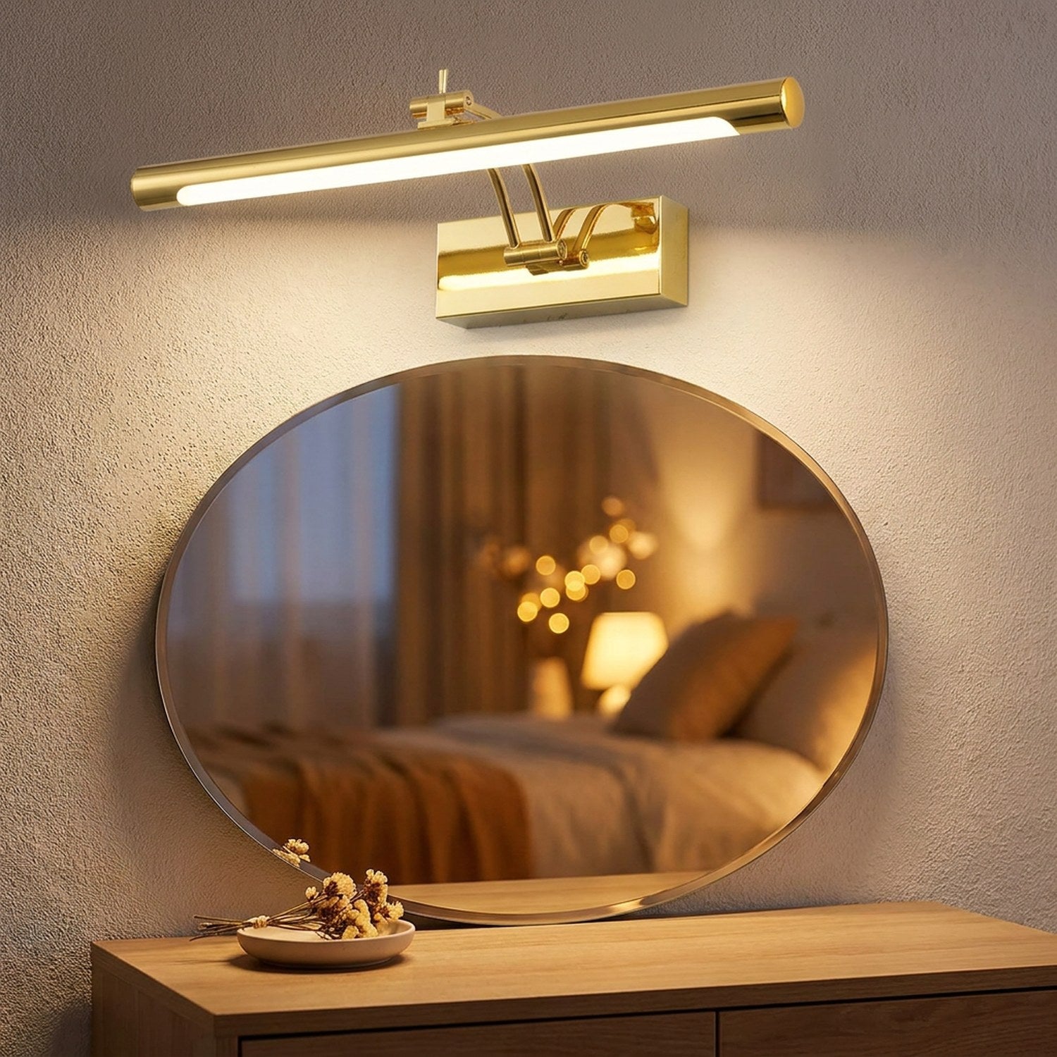 Applique murale miroir LED dorée au-dessus d'un miroir ovale sur une coiffeuse en bois