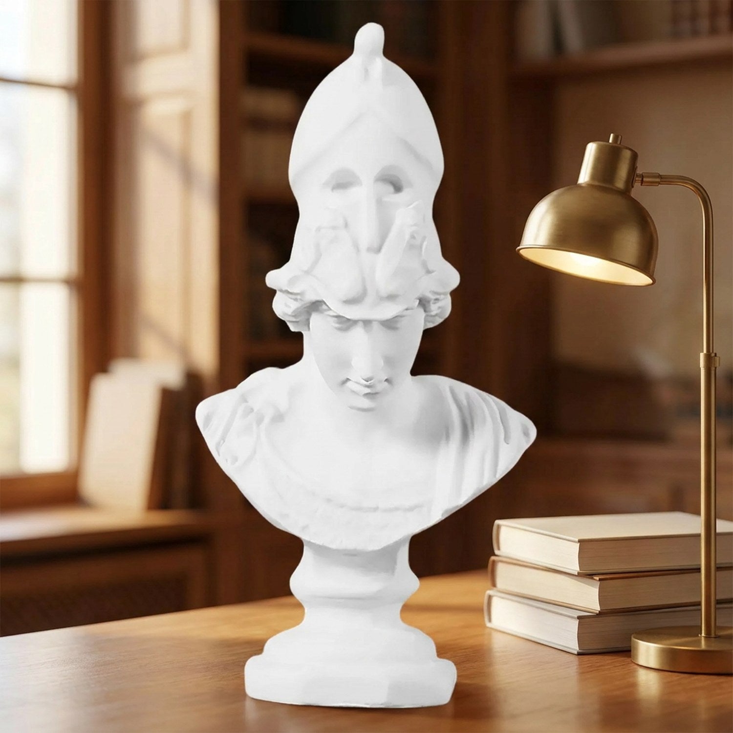 Statue Athéna sur un bureau en bois près d'une fenêtre avec une lampe et des livres