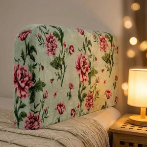 Gros plan sur le velours doux d'une housse de tête de lit à motif de roses éclairée par une lampe chaude