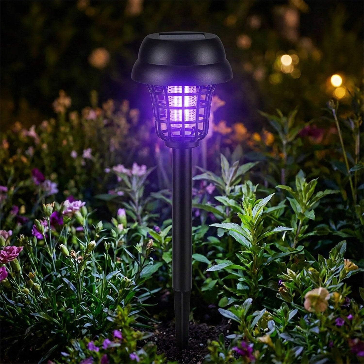 Gros plan d'une lampe anti moustique solaire à lumière violette dans un massif de fleurs la nuit