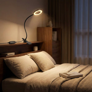 Lampe de chevet à pince fixée sur une tête de lit dans une chambre chaleureuse