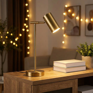 Lampe de bureau dorée allumée sur une console de salon cosy