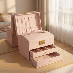 Boîte à bijoux rose ouverte sur une table en bois près d'une fenêtre