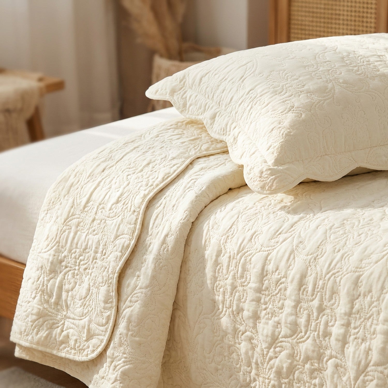 Gros plan sur la texture matelassee en relief du couvre-lit ivoire et sa taie assortie