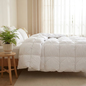 Couette matelassée blanche sur un lit dans une chambre lumineuse aux tons naturels