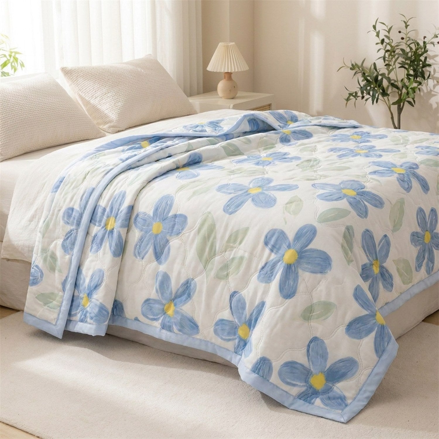 Couette d'été à fleurs bleues sur un lit avec table de chevet en bois et lampe