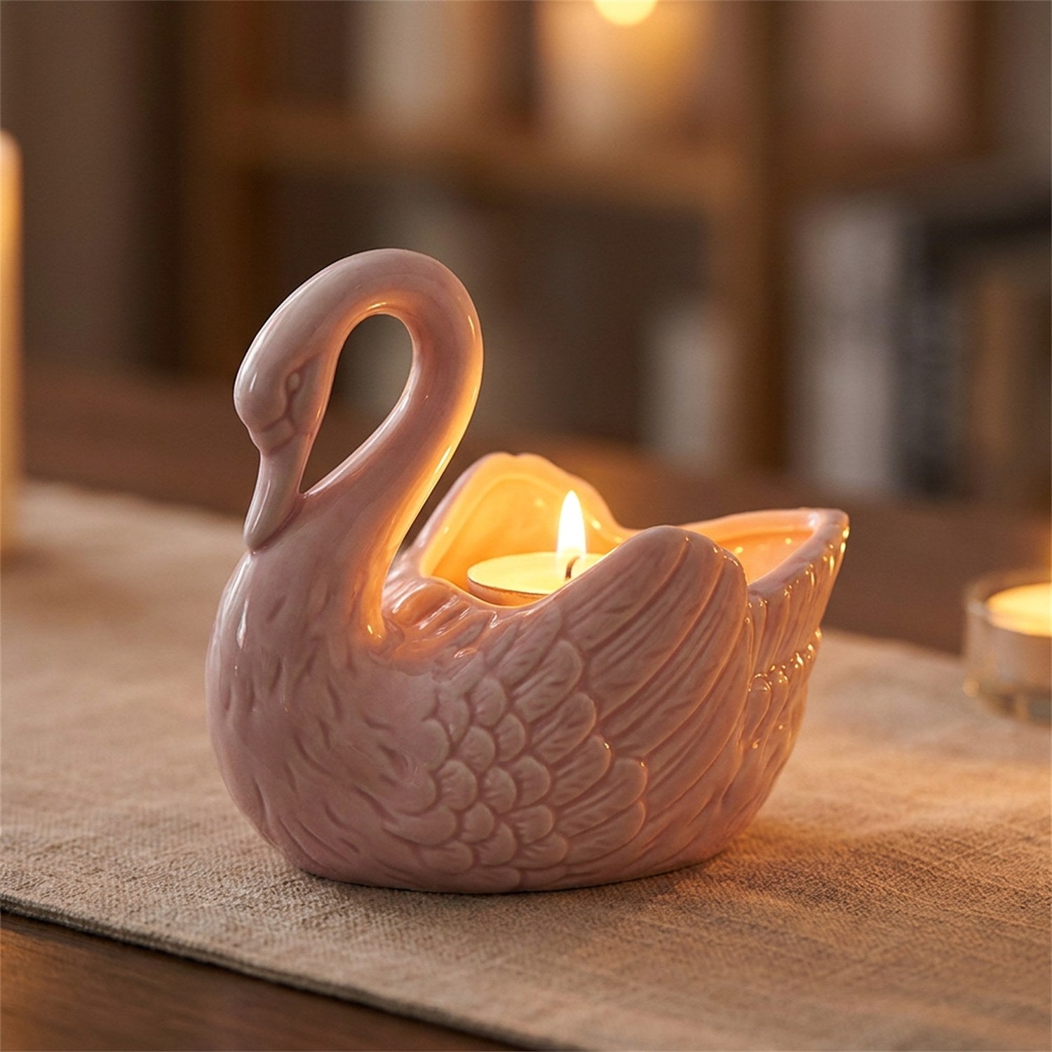 Vase cygne rose transformé en photophore avec une bougie chauffe-plat allumée