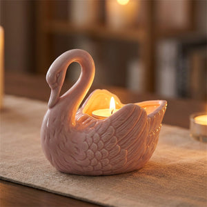 Vase cygne rose transformé en photophore avec une bougie chauffe-plat allumée