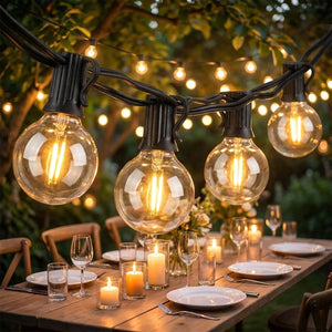 Guirlande lumineuse à ampoules guinguette suspendue au-dessus d'une table de jardin dressée le soir
