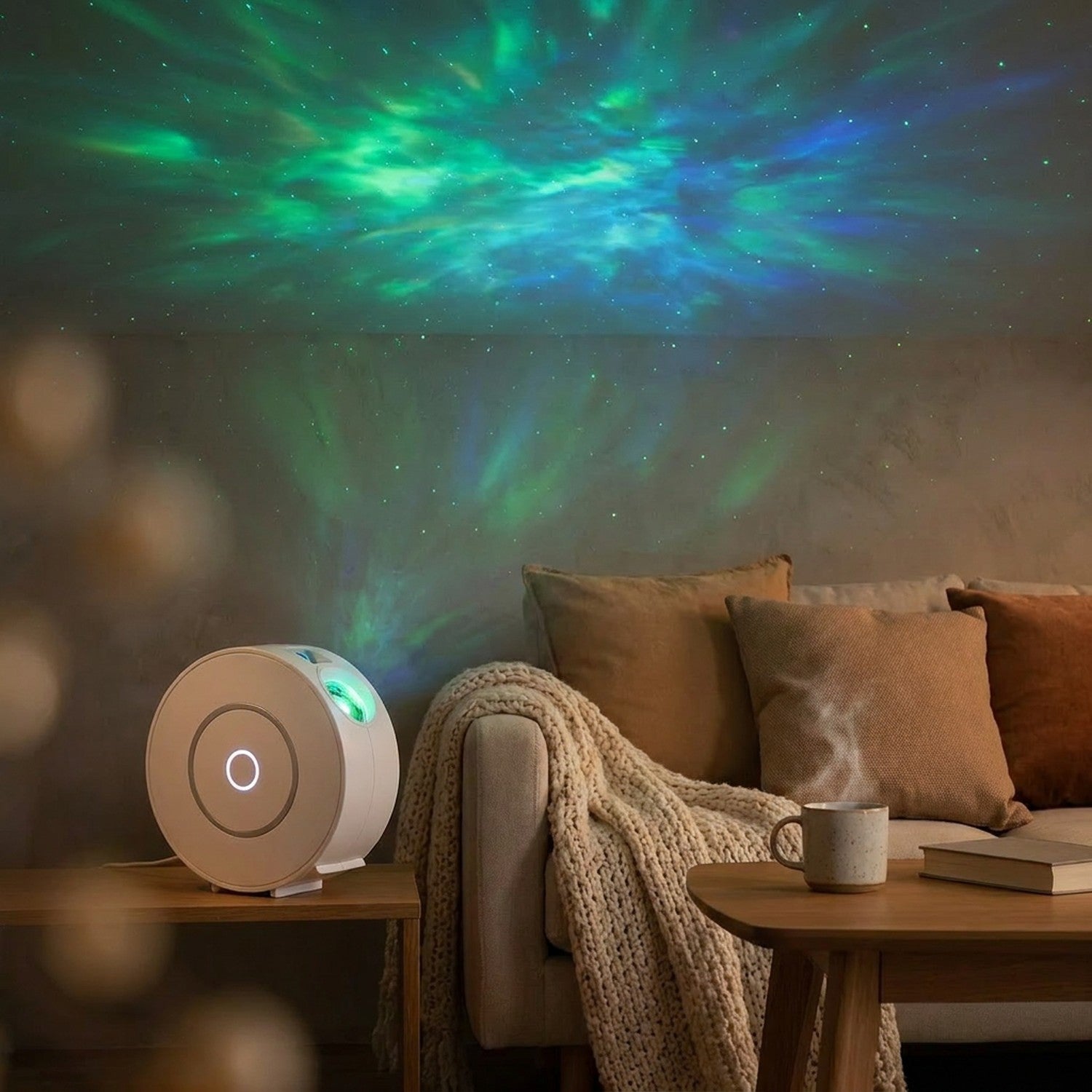 Projecteur de ciel étoilé sur une console de salon projetant une aurore verte au-dessus d'un canapé