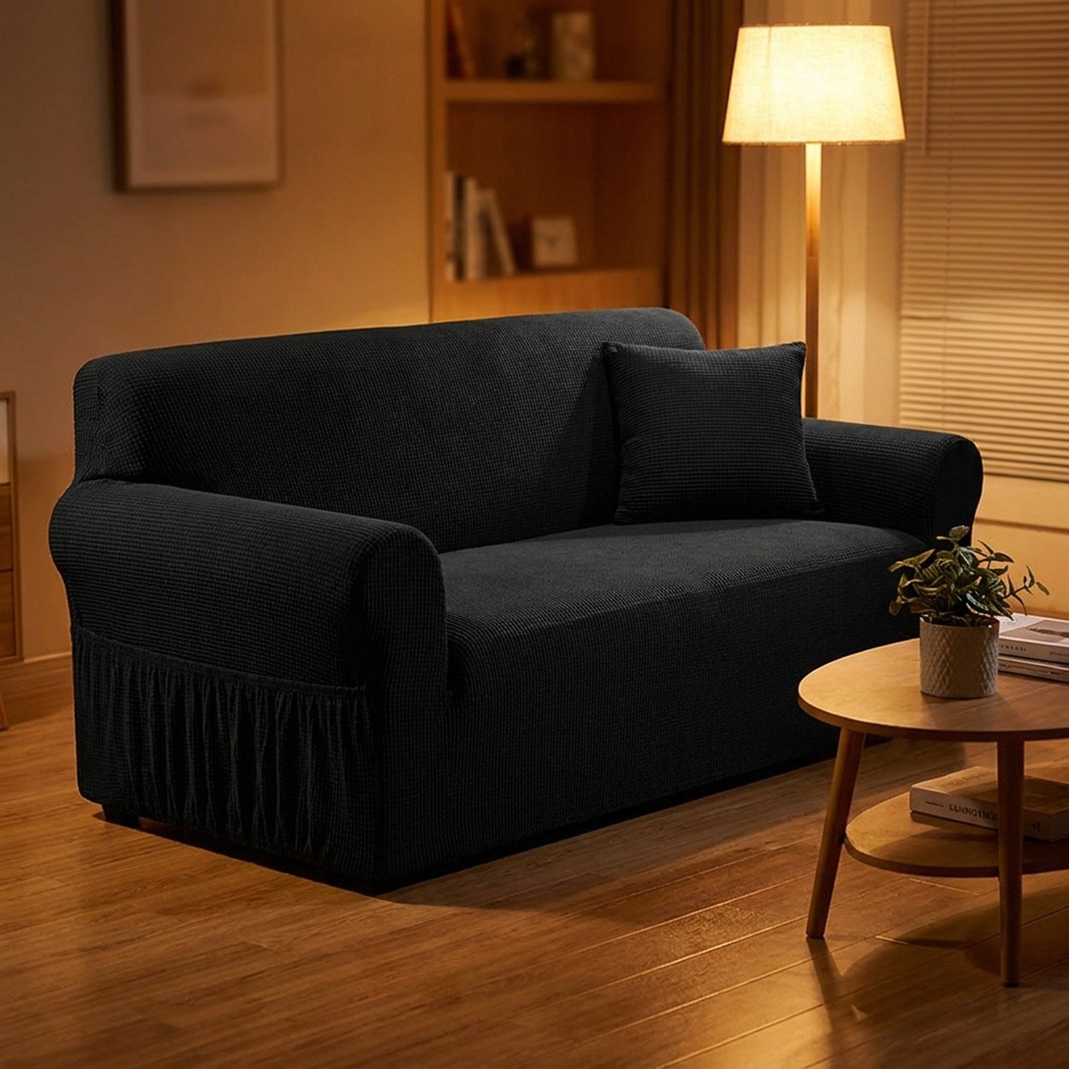 Housse de canapé noire dans un salon cocooning en soirée avec lampadaire