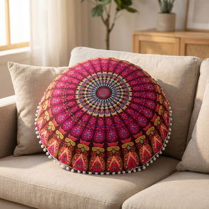 Housse de coussin mandala bordeaux posée sur un canapé en lin avec des coussins neutres