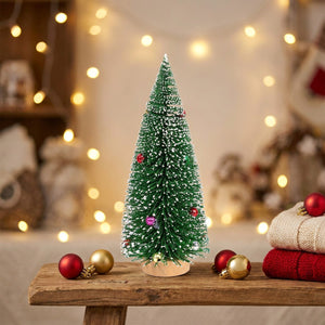 Sapin de Noël miniature vert givré posé sur une étagère en bois avec décorations de fête