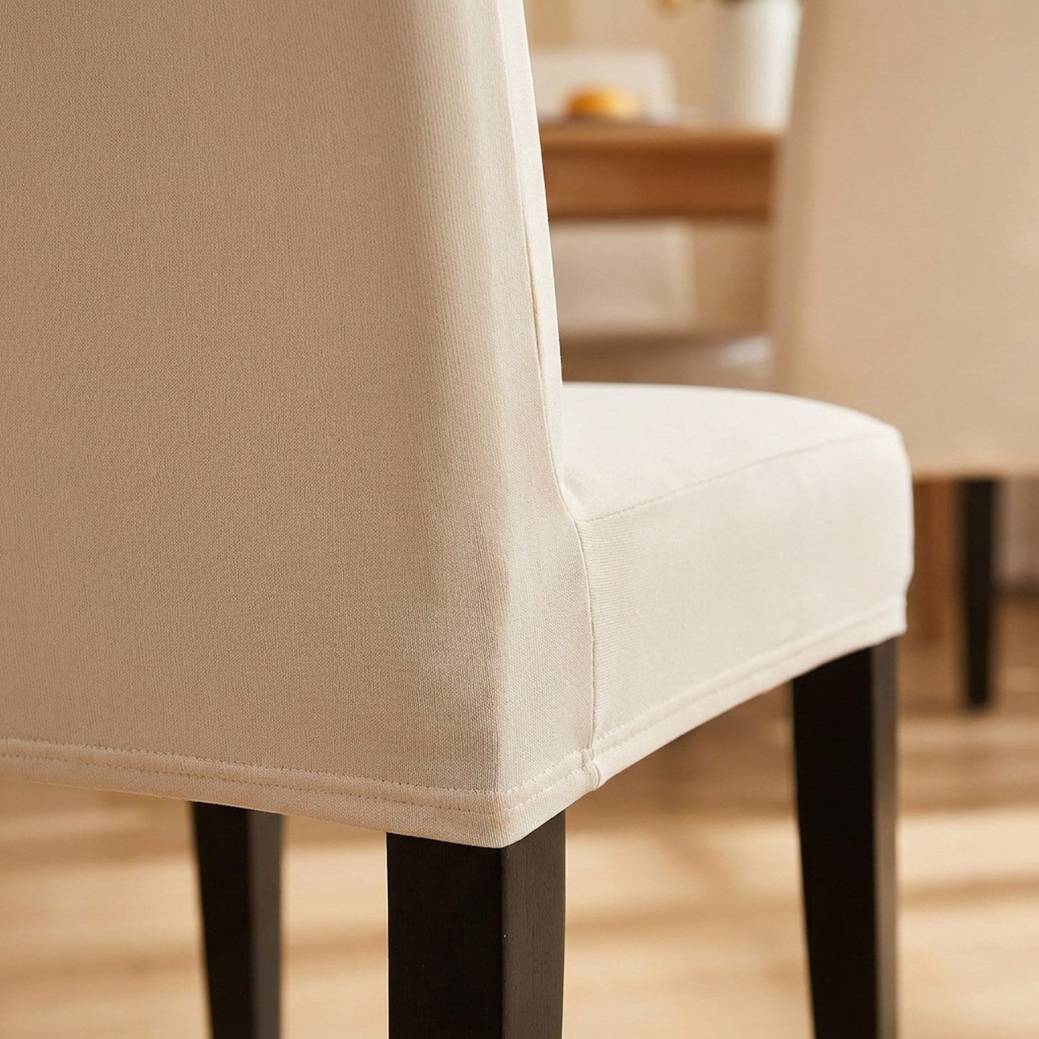 Détail de la couture et du tissu extensible de la housse de chaise beige