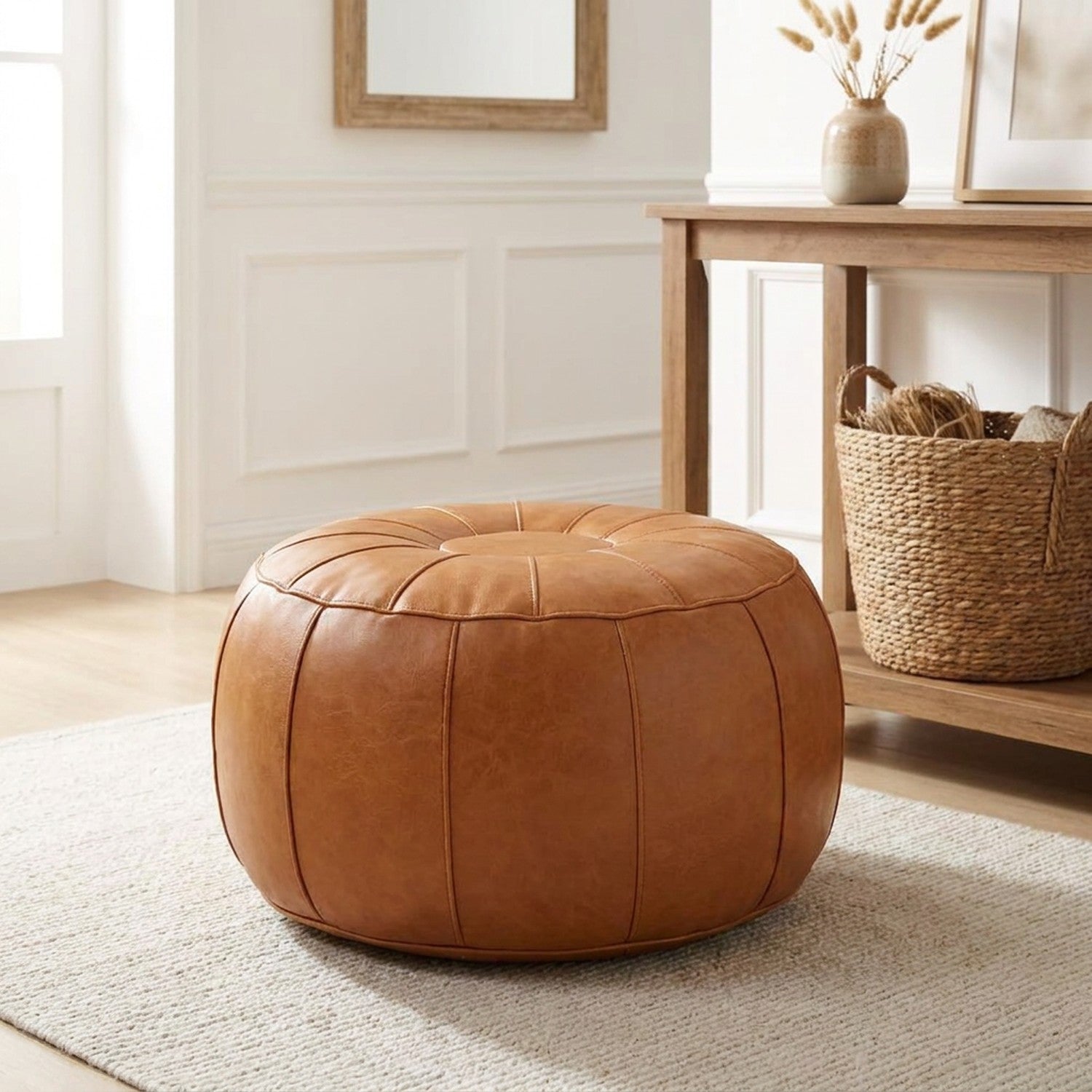 Pouf de rangement caramel dans une entrée près d'une console en bois
