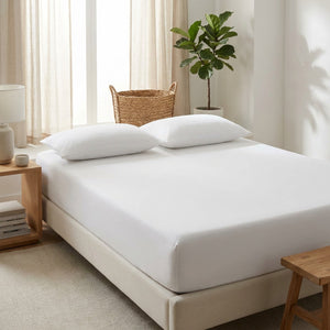Drap-housse blanc sur un lit dans une chambre lumineuse au style scandinave