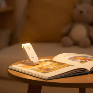Lampe de lecture clipée sur un livre illustré pour enfant le soir