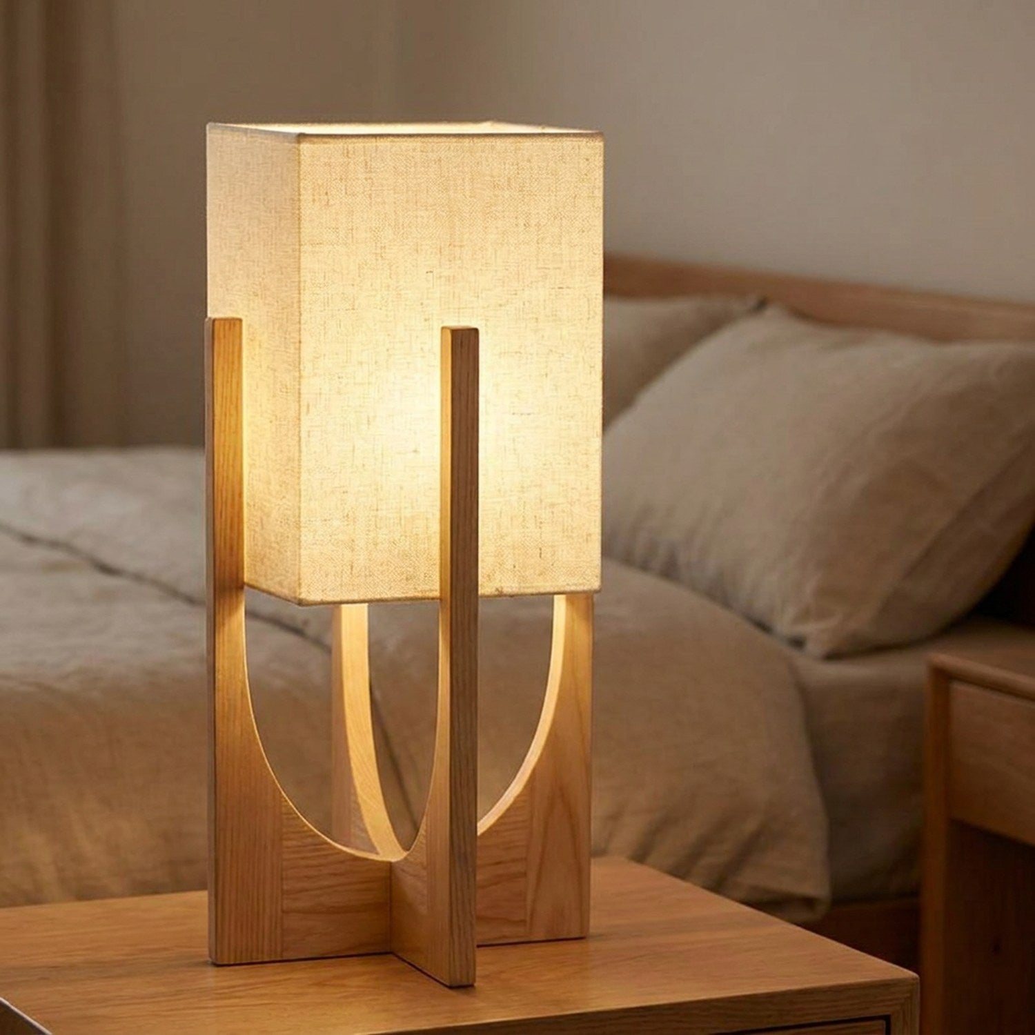 Lampe japonaise en bois clair posée sur une table de chevet dans une chambre cosy