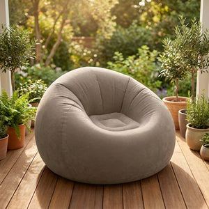 Fauteuil gonflable gris sur une terrasse ensoleillée entourée de plantes
