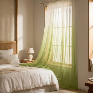 Voilage tulle dégradé vert dans une chambre cosy avec lit et table de chevet