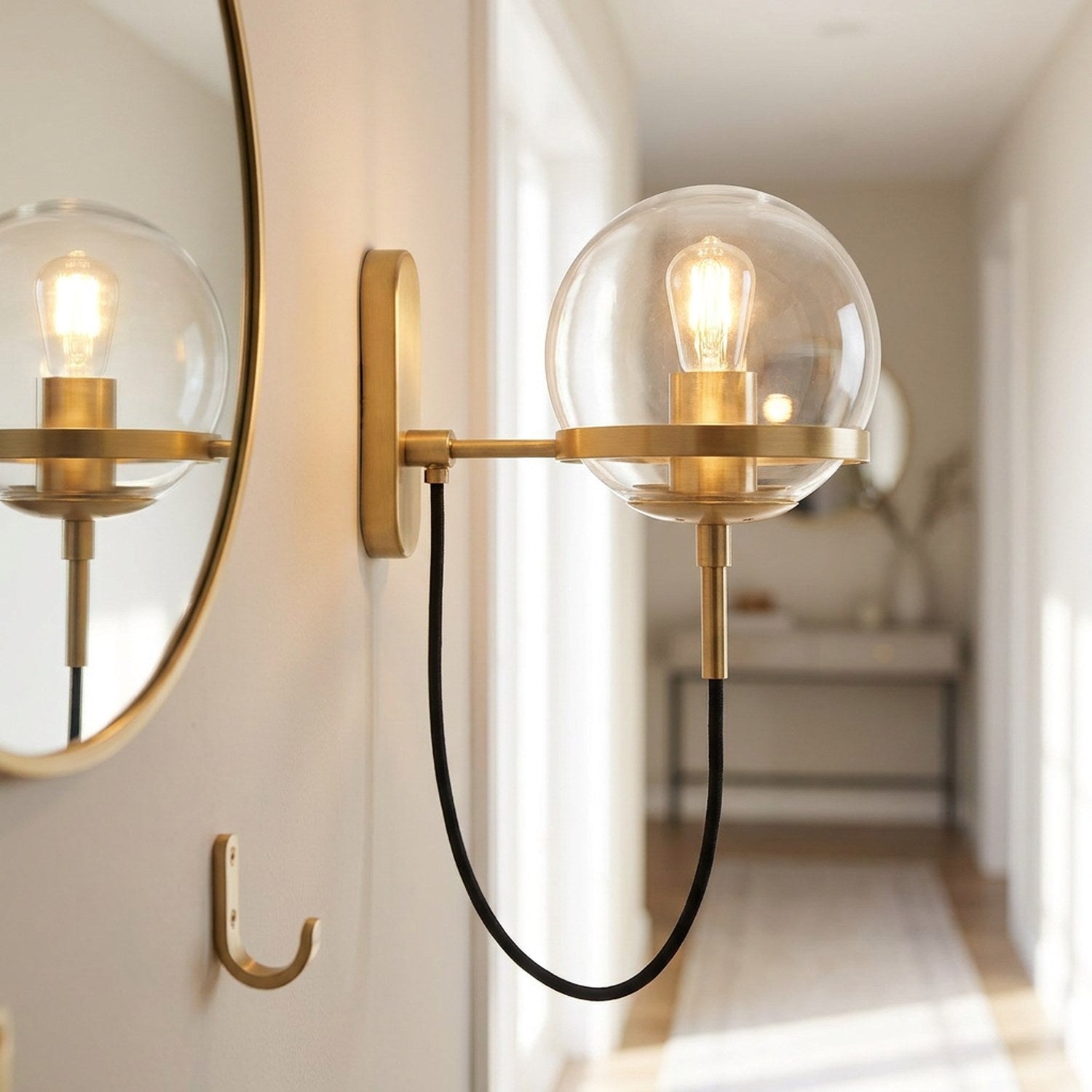 Applique murale boule de verre dorée près d'un miroir dans une entrée chaleureuse