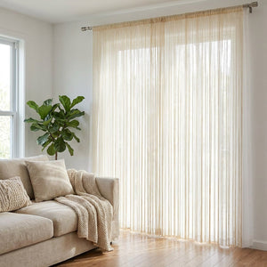 Rideau à fil beige suspendu devant une grande fenêtre lumineuse