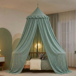 Moustiquaire à dôme vert sauge suspendue au-dessus d'un lit à barreaux dans une chambre de bébé